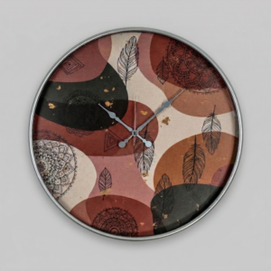 Loravien Plume Large-Scale Artistic wall clock with a 50 cm dial featuring bohemian feather and mandala motifs in earth tones, silver vintage hands, and a slim metallic frame.